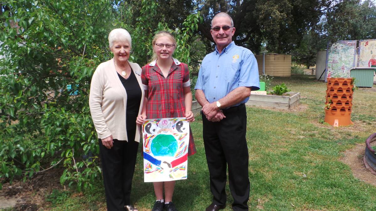 ART FOR PEACE: Heather Bailey, Lily Rice and Stuart Fruedenstein and Lily's winning artwork. Photo: Supplied.