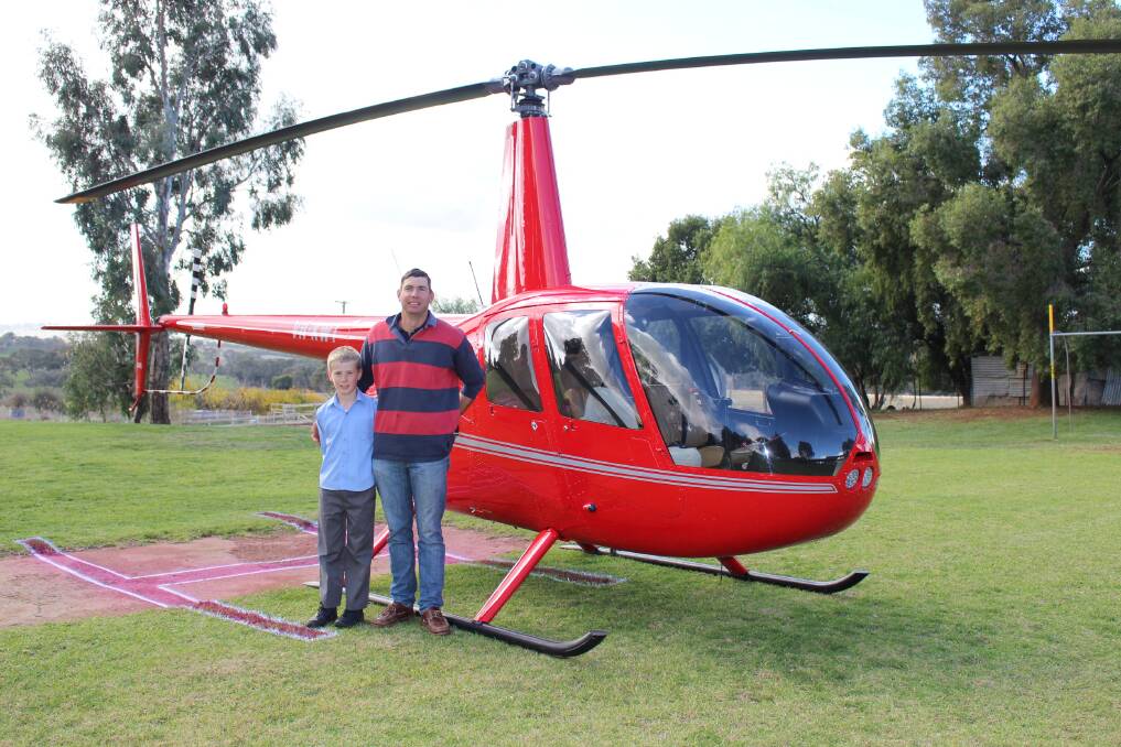 RAFFLE WINNER: Winner of the Maimuru Public School raffle Angus Steenbergen and his father, Kyeran with the helicopter they took their ride on.