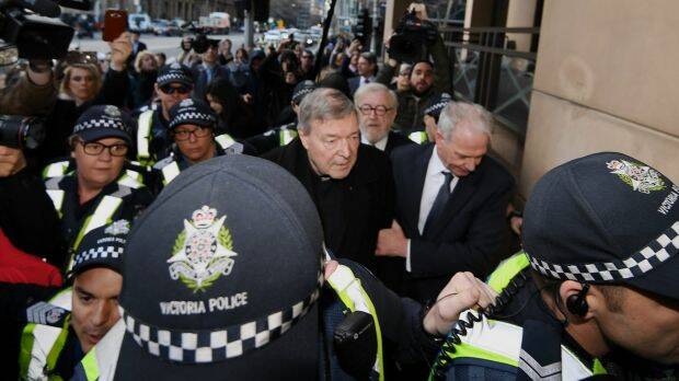 Cardinal George Pell arrives at Melbourne Magistrates Court surrounded by police, and his lawyers. Photo: Justin McManus
