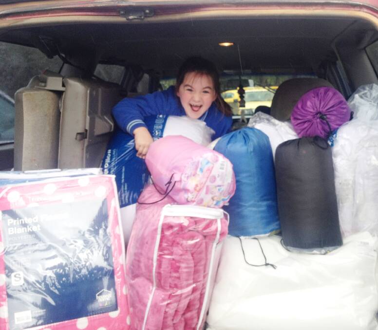 Clare Daley was all smiles when loading the blankets, sleeping bags and bedding she donated to St Vincent de Paul after raising $201 from her birthday party. The Young branch require more winter clothing and bedding.