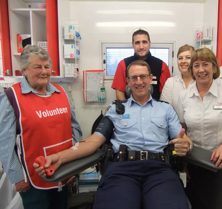 HELPING: Young Police's Senior Constable Joseph Zuzek is assisted in donating blood by Red Cross' Helen Ricketts (volunteer), Dagmar Voss, Kim Bardwell and Belinda Meek.