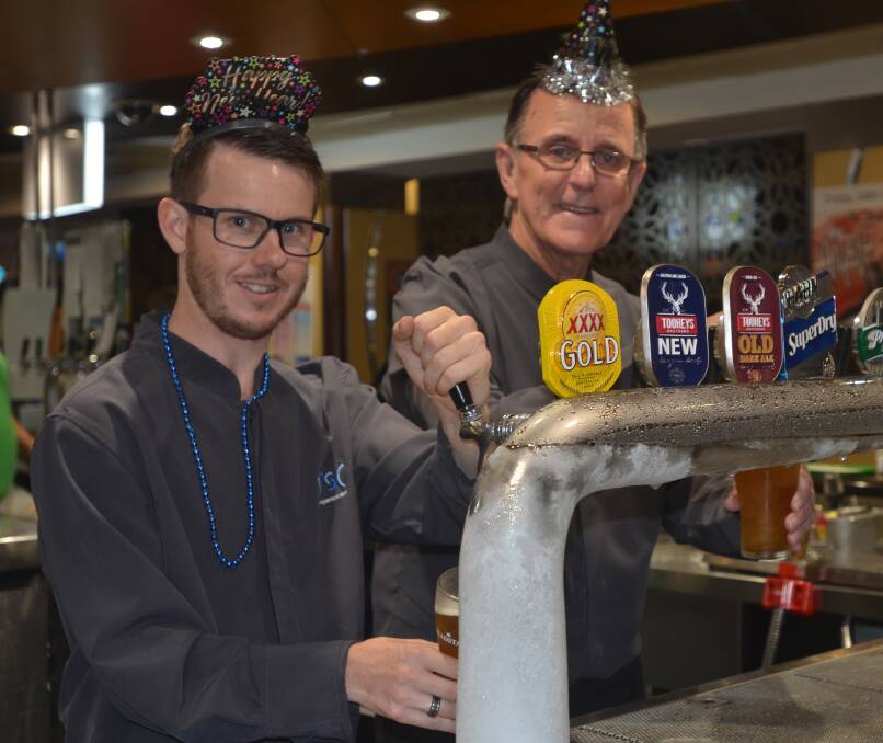  David Munnerly and Gary Quinn pulling beers at the services club.