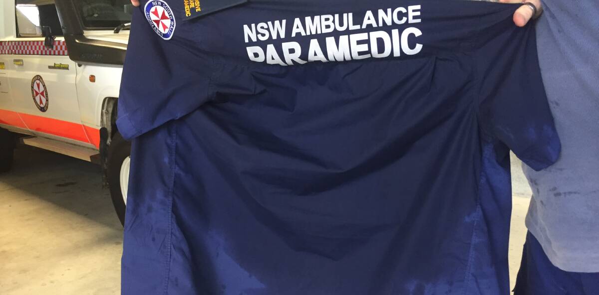 SWEATY WORK: A NSW Ambulance paramedic holds up his sweaty uniform. Picture: Supplied.