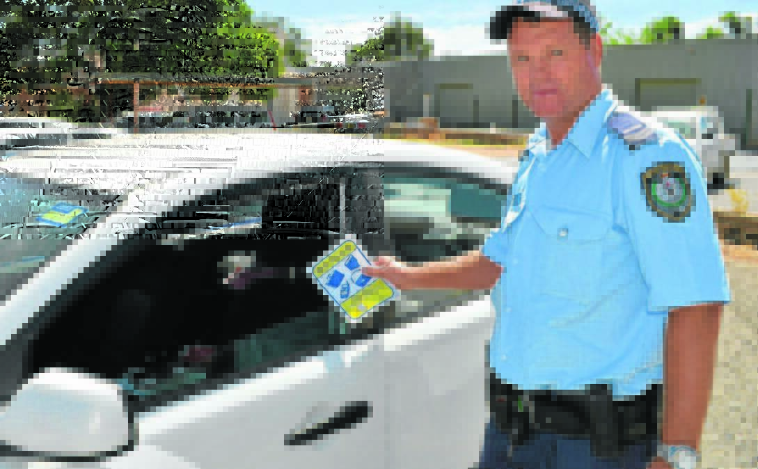 PARK SMARTER: Cootamundra Local Area Command (LAC) Crime Prevention Officer Senior Constable Peter Guthrie next to an unsecured car.