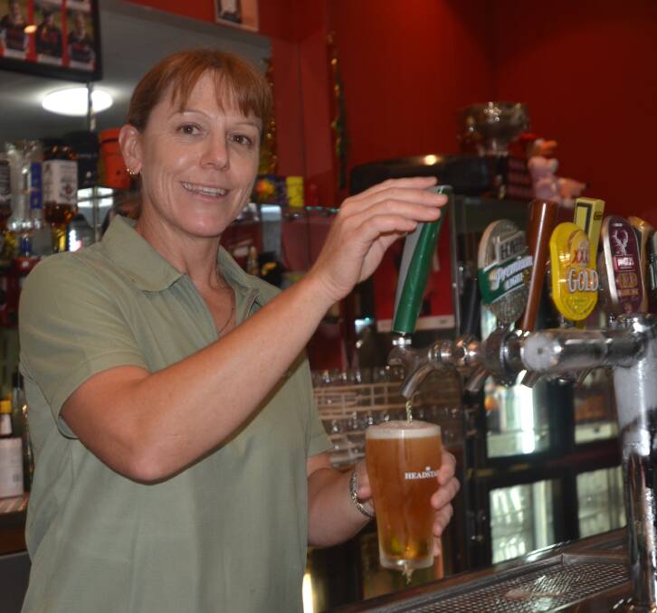 THIRST QUENCHER: Leslie Johnson pours a beer on New Year's Eve at the Young Bowling club. Picture: Craig Thomson.