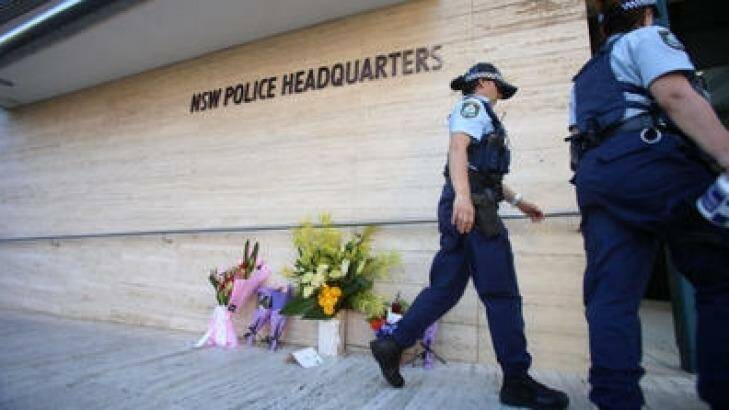 Police officers leave flowers outside police headquarters in Parramatta, after employee Curtis Cheng was shot. Photo: James Alcock