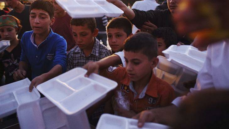Displaced Syrian Kurdish children queue for food in Suruc in October, the nearest town to the Turkish border. Photo: Andrew Quilty