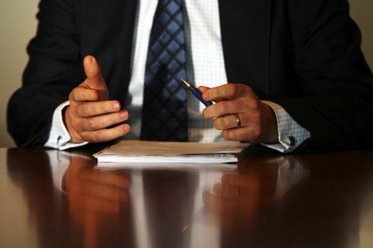 Businessman holding a pen sitting at a desk. Generic paperwork, director, office work, white collar, boardroom. Tuesday 1 August 2006 BRW photo Louie Douvis   AFR FIRST USE ONLY SPECIALX 54233