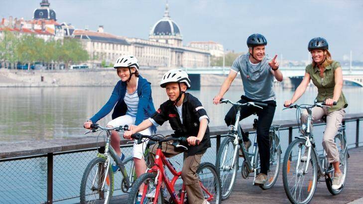 A family cycling along the riverbanks during a Uniworld shore excursion.