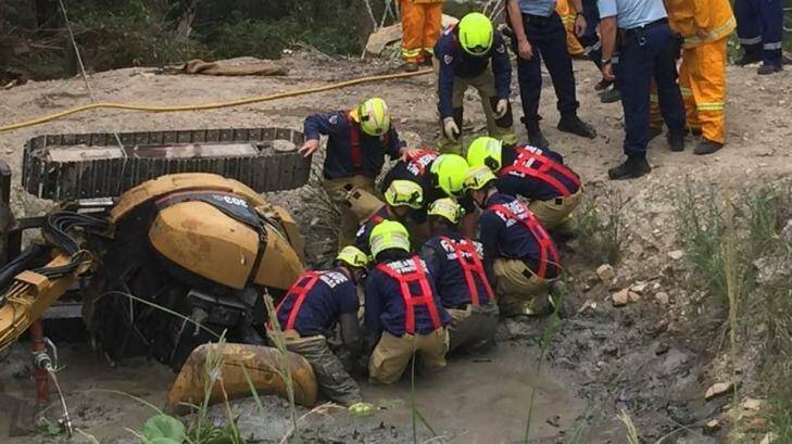 Firefighters work to free Dan Miller from the dam at his property in Charlotte Bay. Photo: Facebook/Saimaa Miller
