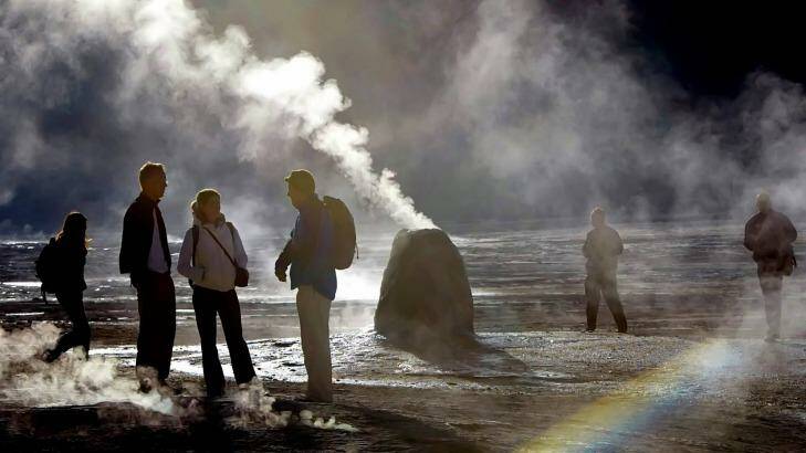 Tourists walk amid the geysers and hot springs of El Tatio, Chile.