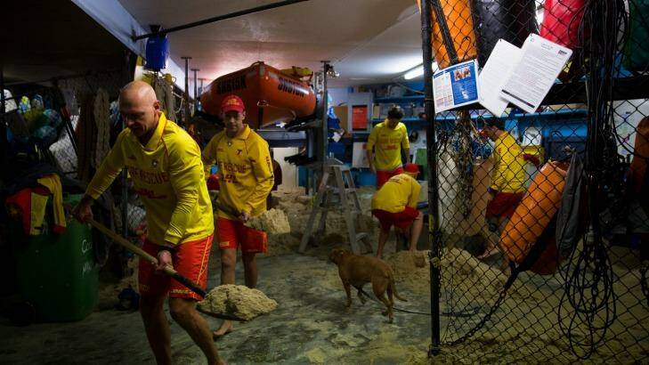Members of the Coogee Surf Life Saving Club clear out their boatshed which was inundated with water and sand during the storms. Photo: Janie Barrett