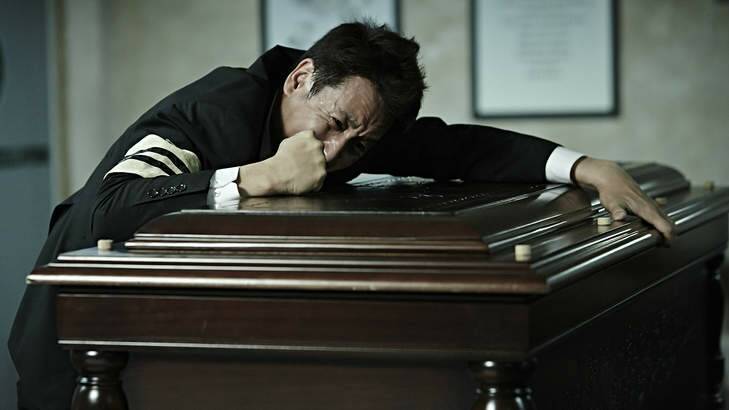 Detective Go Geon-soo (Seon-gyun Lee) weeps on his mother's coffin in <i>A Hard Day</i>.