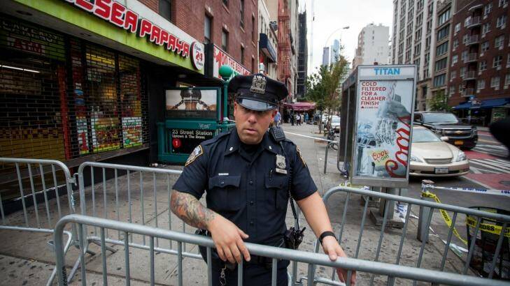 A New York City Police Department officer places barricades near the site of Saturday night's explosion in Chelsea.  Photo: Michael Nagle