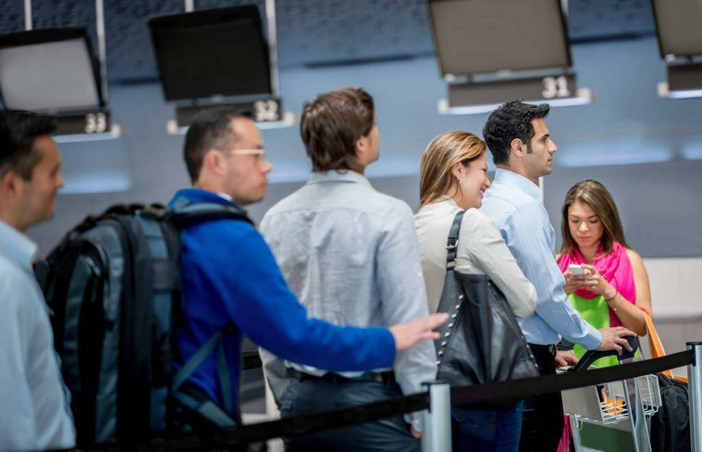 Group of people at the airport in line for the check-in counter  Photo: iStock