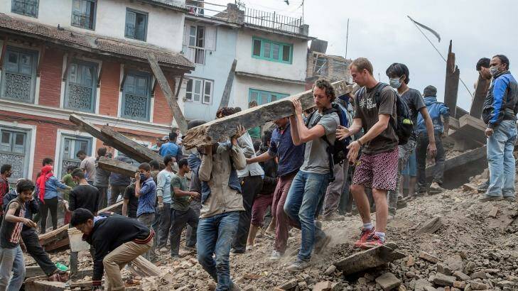 Emergency workers and bystanders clear debris while searching for survivors under a collapsed temple in Basantapur Durbar Square following an earthquake. Photo: Omar Havana