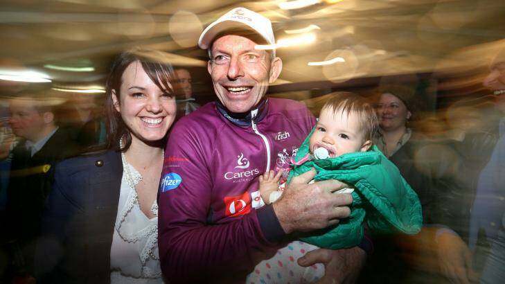 Sore but relieved: After crossing the finish line, Tony Abbott is greeted by Rebecca Goldfinch, wife of a local councillor, and her baby Dakota. Photo: James Alcock
