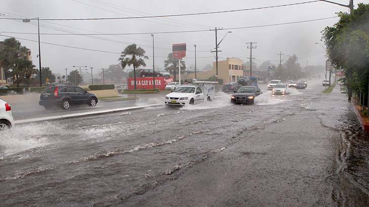 Flash flood: motorists drive through water on the Princes Highway at Carlton. Photo: Jane Dyson