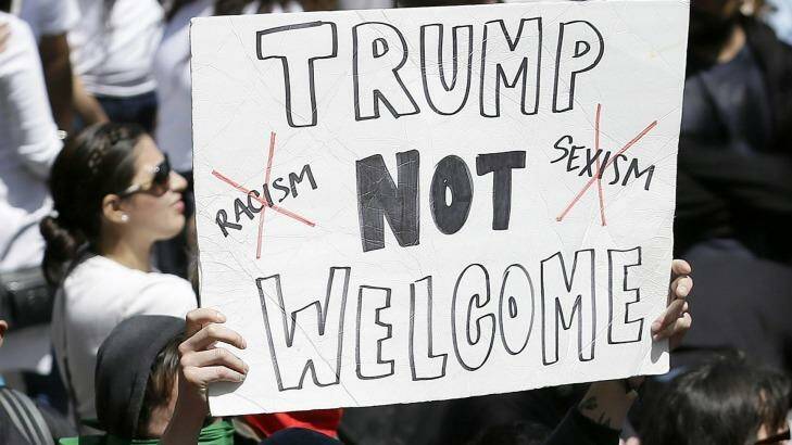 A protester holds up a sign against Republican presidential candidate Donald Trump outside of the Hyatt Regency hotel where Trump was speaking. Photo: Eric Risberg