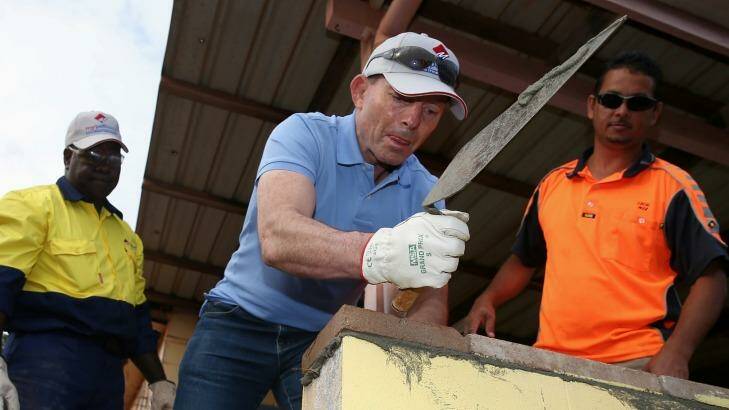 Tony Abbott assists in the Injinoo  community hall upgrade during his visit to Cape York. Photo: Alex Ellinghausen