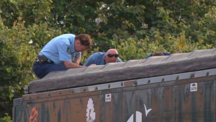 Police look into the back of the sand-blowing truck, where the man's body was found. Photo: Justin Wilson