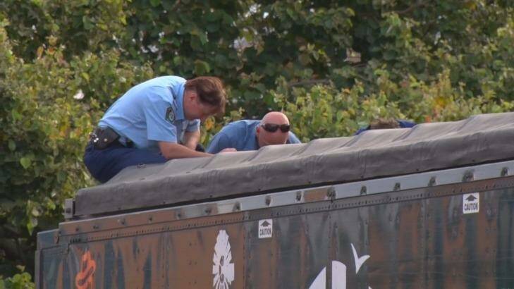 Police look into the back of the sand-blowing truck, where the man's body was found. Photo: Justin Wilson