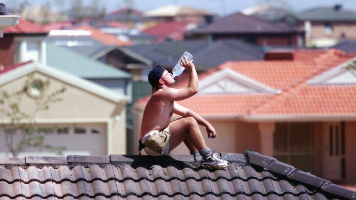 DIGICAM 00005050 sms000208.001.003.jpg  for General News.   Picture by Simon Schluter, The Age, Melbourne.   The Heat in Melbourne.  Pic shows plummer Conrad Winship cooling himself down while working on a rooftop in Caroline Springs estate. Photo: Simon Schluter