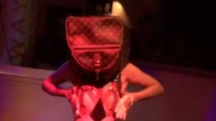 A striptease performer, wearing a bag on her head, emerges from a birthday cake at M&C Saatchi's 21st birthday party. Photo: YouTube