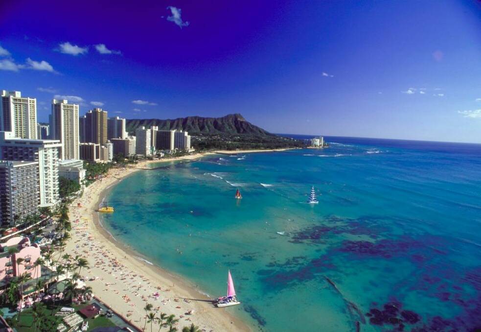 Soak up the sun at Waikiki Beach in Hawaii or take a lesson in surfing.