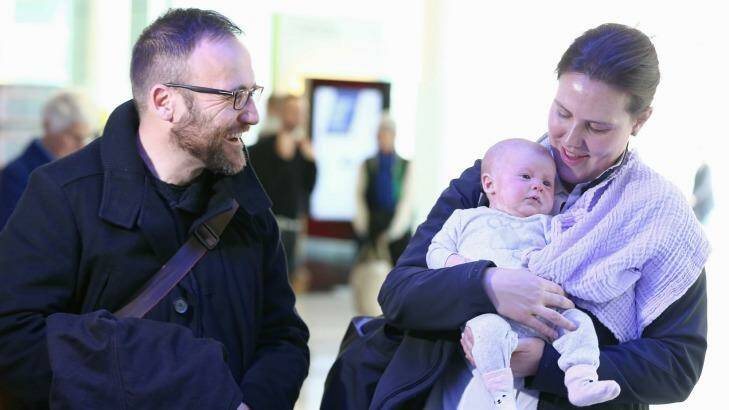 New father Greens MP Adam Bandt greets Ms O'Dwyer and Olivia at Canberra Airport, arriving for the return of Parliament this week. Photo: Alex Ellinghausen