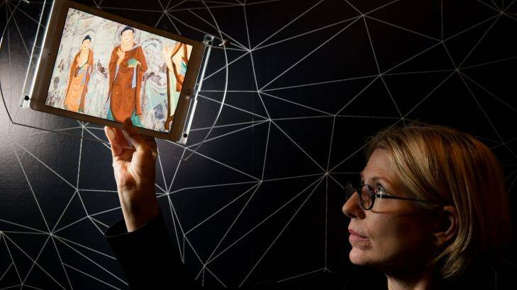 Professor Sarah Kenderdine demonstrates the augmented technology that reveals details of the Tang Dynasty cave wall mural. Photo: Janie Barrett 