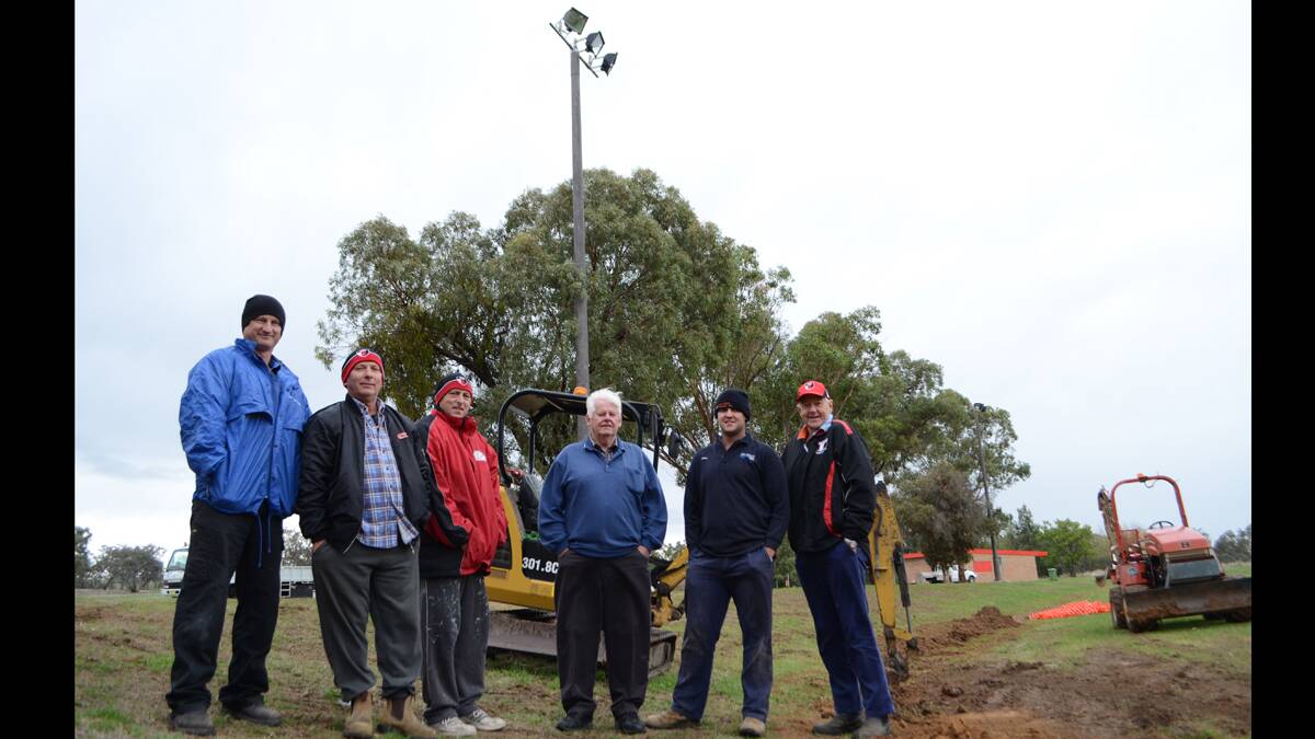 THRILLED: Young Saints AFL Club president Anthony Webb, reserve grade coach Ian Callaghan, secretary and 18s coach Ray Martin, vice president Rence Cummins, treasurer Patrick Watkin and publicity officer Geoff Harmer are excited the old lights (pictured) are soon to be a thing of the past at Burrangong Oval. 		            (lighting (18))