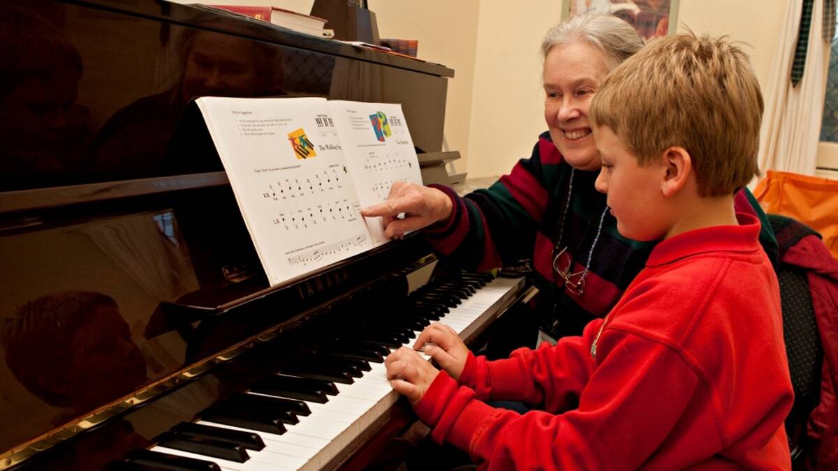 PRACTICE: Tennyson Neville (piano student) has come a long way in the two years since this engaging photo was taken with his tutor Margaret Edwards.  