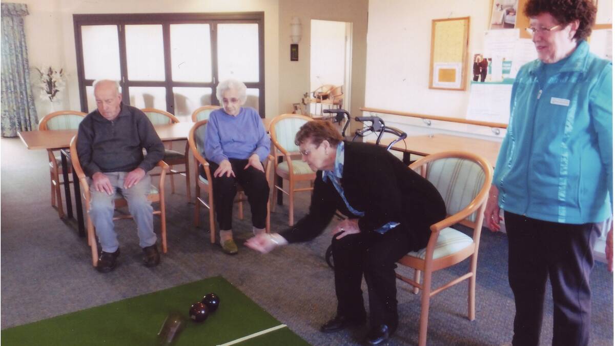SOMETHING NEW: Southern Cross Retirement Village residents Max Holmes and Ollie McManus watch on as Joyce Hampton gives it her best shot at indoor bowls as organiser Wilma Galvan observes.               (sub)