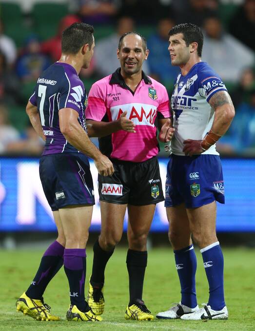 Referee Ashley Klein talks with captains Cooper Cronk and Michael Ennis during the round four NRL match between the Canterbury-Bankstown Bulldogs. Picture: Getty