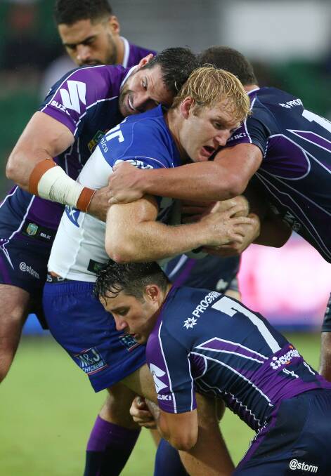 Aiden Tolman of the Bulldogs is tackled by Brian Norrie and Cooper Cronk during the round four NRL match. Picture: Getty