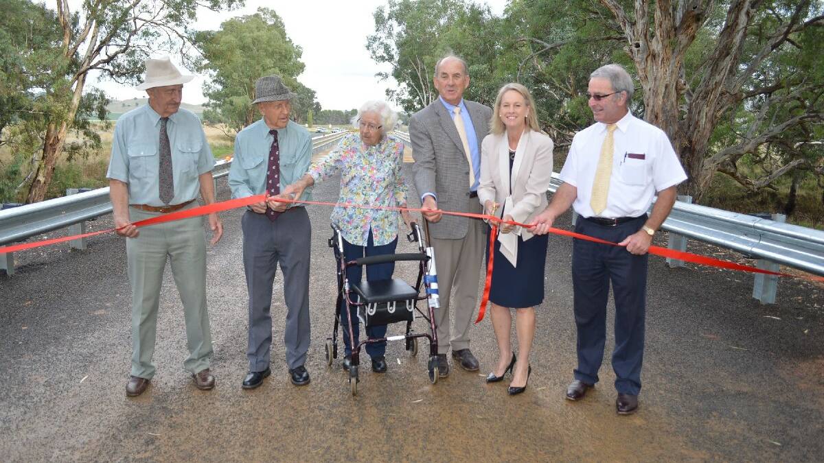 Back to future for bridge opening: Siblings Col and Ron Fisher, and Joyce Siegert help Cowra mayor Bill West, Senator Fiona Nash and Young mayor Stuart Freudenstein cut the ribbon to officially open the Greenethorpe Road bridge at Back Creek last Wednesday morning.