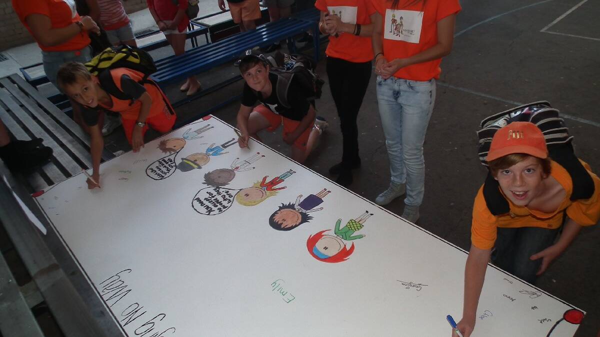 Students make anti-bullying pledge: As part of Young High School’s mental health initiatives, the entire school took part in the National Day of Action Against Violence and Bullying. Pictured students signing a pledge not to bully. 
