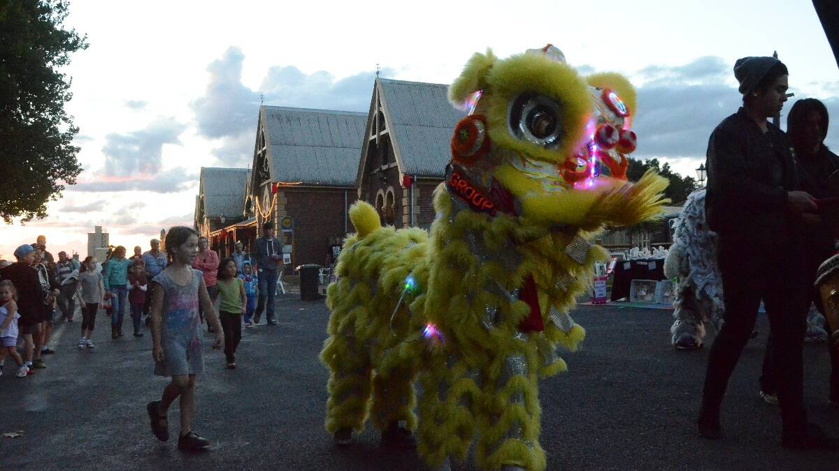 FOLLOWING: Youngsters just couldn't resisting touching the spectacular dancing lions in Anderson Park at the Lambing Flat Chinese Festival.