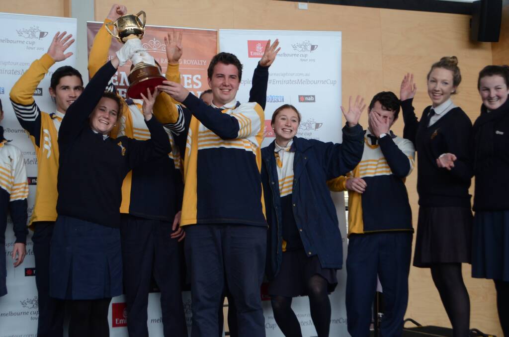 VICTORY: Hennessy Catholic College student and school leader Sammy Maxwell holds the Cup with Jake Cummins and the rest of the school’s leadership team on Wednesday during its tour of Young.