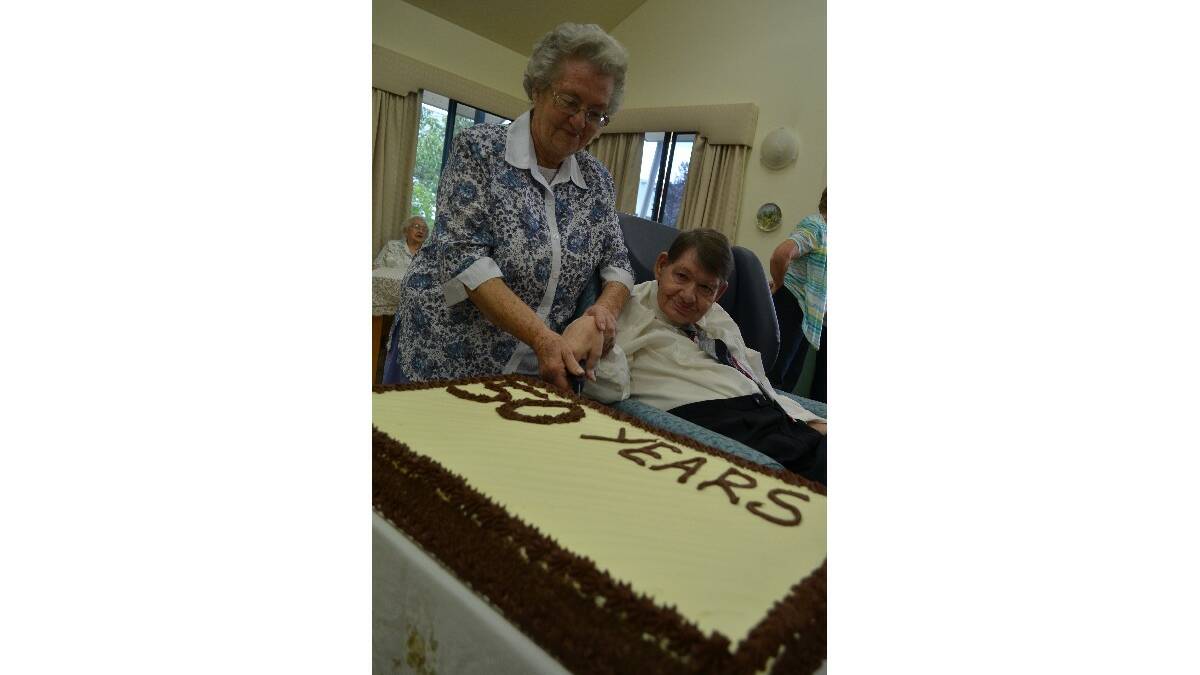 YUM! Barry Elkins’s sister Fay Hill helps him cut the 50 year celebratory cake.    Photos by Christine Speelman