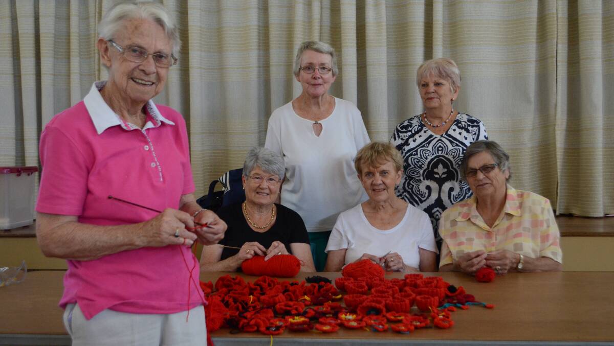 POPPIES: Busily knitting away in the lead-up to Anzac Day are Barbara Duggan (front), and back (left to right) Dianne Rembke, Chris Page, Betty McDonald, Judith Langfield and Mary Whitechurch. They are pictured with the 60 plus knitted poppies. 	