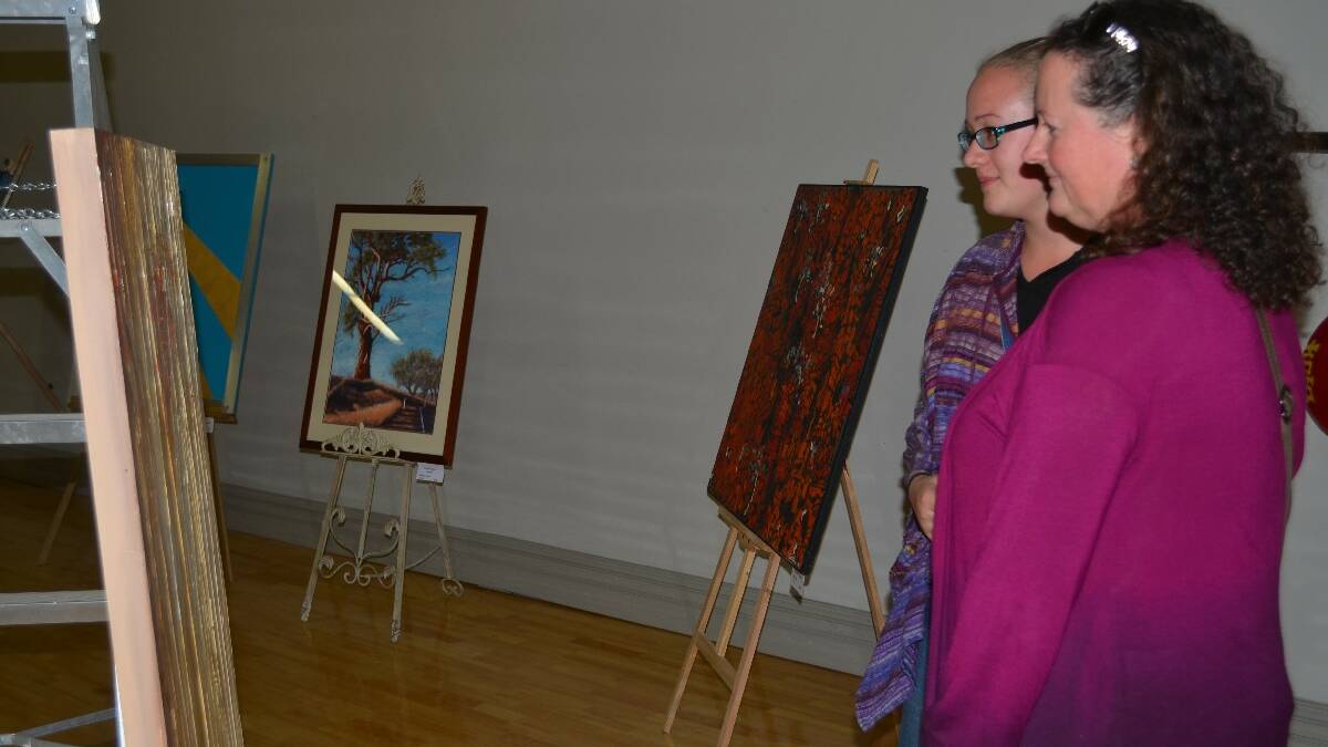 ART: Shiraz Costello of Sydney (left) and Wendy Hartley of Young look at a painting featured in the Lambing Flat Chinese Festival Sculpture, Wood and Big Art exhibition at Young Town Hall.