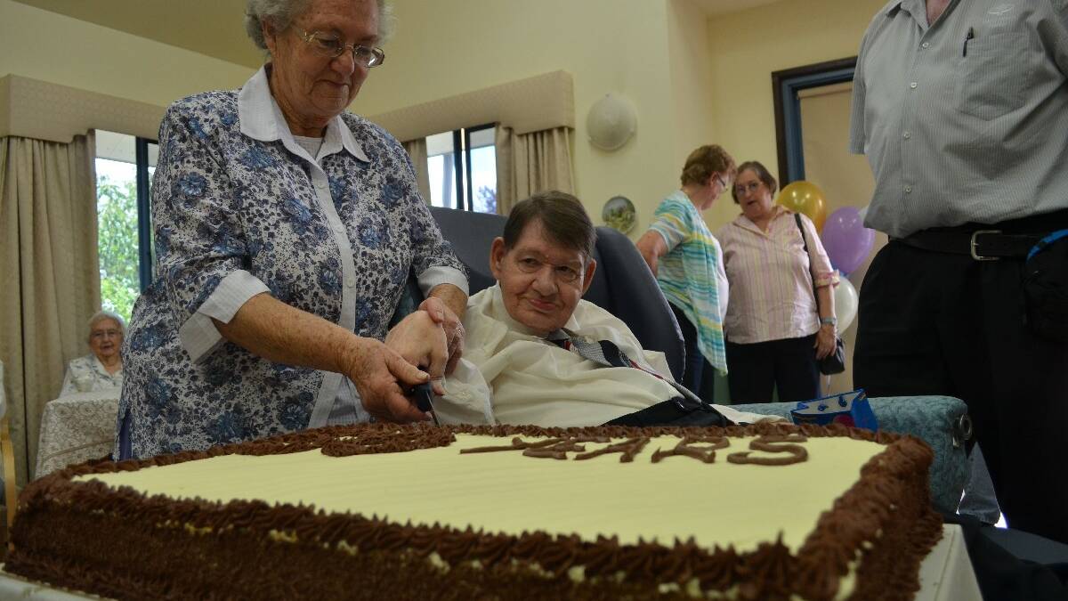 YUM! Barry Elkins’s sister Fay Hill helps him cut the 50 year celebratory cake.    Photos by Christine Speelman
