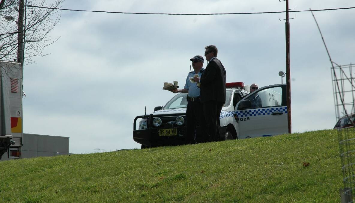 SEARCH: A Homicide Squad detective and local police watch on.