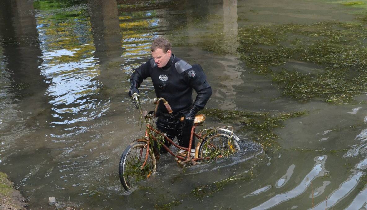 SEARCH: An old bike is pulled out from the creek. 
