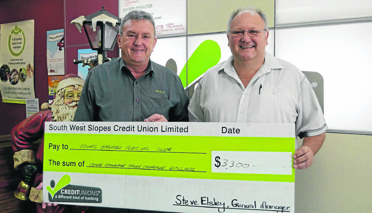 CHEQUE: South West Slopes Credit Union general manager Steve Elsley presenting Young Harness Racing Club president Garry Cummins with a $3300 cheque to help fund for the upcoming Carnival of Cups to be held in March. (CPharness 001)
