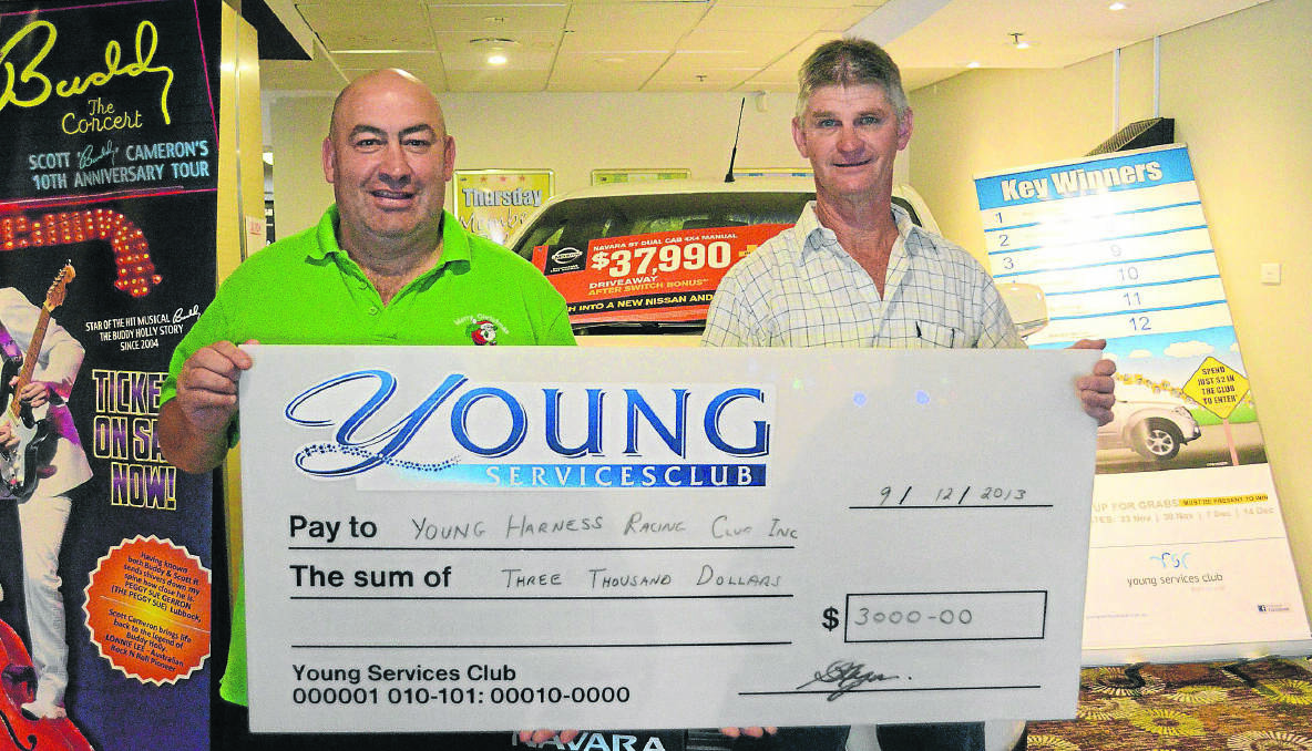 CHEQUE: Young Services Club’s senior supervisor Bradley Pettit hands Young Harness Racing Club secretary Brian Ingram a cheque of $3000 to go toward club promotion.		   (CPharnessclub)