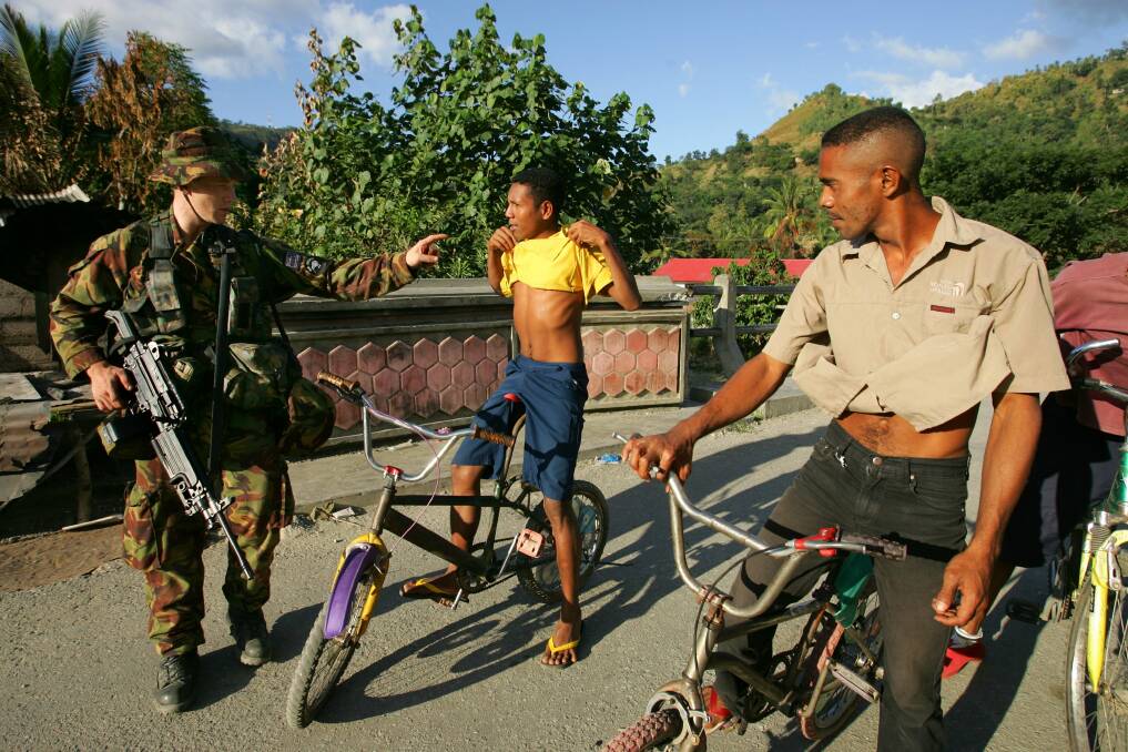 A New Zealand peacekeeper checks locals for weapons at a check point June 3, 2006 in Dili, East Timor. Photo by Paula Bronstein/Getty Images