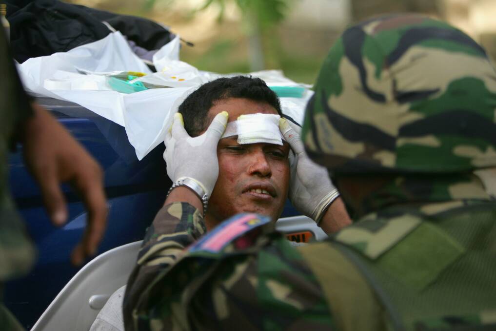Kiki gets first aid by the Malaysian peacekeeping troops after being hit with a rock by rival gangs members on June 8, 2006 in Dili, East Timor. Photo by Paula Bronstein/Getty Images